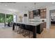 Spacious kitchen with a large marble island, wood cabinets and black pendant lights at 7436 Summer Tanager Trl, Raleigh, NC 27614