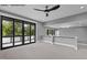 Modern living room featuring recessed lighting, a stylish ceiling fan, and a large sliding glass door at 7436 Summer Tanager Trl, Raleigh, NC 27614