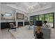 Spacious living room with fireplace, built-in shelves, a modern light fixture, and access to backyard at 7436 Summer Tanager Trl, Raleigh, NC 27614