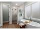 Bright bathroom featuring soaking tub next to walk-in shower with marble tile and rain shower head at 749 Golfers Vw, Pittsboro, NC 27312