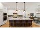 Bright kitchen with stainless steel appliances, a large island with seating, and stylish pendant lighting at 749 Golfers Vw, Pittsboro, NC 27312