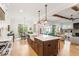 Bright kitchen with a large island, modern appliances, a farmhouse sink, hardwood floors and an open plan living space at 749 Golfers Vw, Pittsboro, NC 27312
