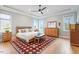 Inviting primary bedroom with tray ceilings, wood floors, and large windows at 749 Golfers Vw, Pittsboro, NC 27312