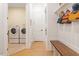 Convenient mudroom area with a bench, coat rack, and a view of the laundry room at 749 Golfers Vw, Pittsboro, NC 27312