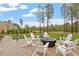 Inviting outdoor patio with white Adirondack chairs and a fire pit, perfect for entertaining and enjoying the backyard landscape at 749 Golfers Vw, Pittsboro, NC 27312