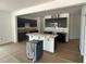Open-concept kitchen with stainless steel appliances, dark cabinetry, and a large center island with a white countertop at 752 Swim Cave Ln, Wendell, NC 27591