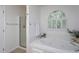 Bathroom with a soaking tub, a separate shower, and a large window at 8000 Elderson Ln, Raleigh, NC 27612