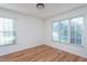 Bright bedroom with large windows and wood-look flooring at 8000 Elderson Ln, Raleigh, NC 27612