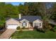 Well-maintained home showcasing lush landscaping, a charming entryway, and attached two-car garage at 8000 Elderson Ln, Raleigh, NC 27612