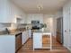Modern kitchen features white cabinets, stainless steel appliances, granite countertops and an island at 8000 Elderson Ln, Raleigh, NC 27612