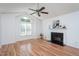 Bright living room with vaulted ceiling, a fireplace, and a large window allowing natural light at 8000 Elderson Ln, Raleigh, NC 27612