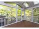 Relaxing screened patio with wood floor, ceiling fan, and beautiful view of the surrounding trees at 8000 Elderson Ln, Raleigh, NC 27612