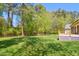 Expansive backyard featuring a lush lawn, wooden deck, and the privacy of a wooded border at 8059 Hogan Dr, Wake Forest, NC 27587