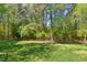 Lush green backyard with mature trees provides privacy at 8059 Hogan Dr, Wake Forest, NC 27587
