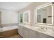 Bright bathroom with double vanity, soaking tub, and illuminated mirrors at 8059 Hogan Dr, Wake Forest, NC 27587