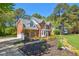 Spacious brick home with a well-maintained lawn and a long driveway leading to the attached garage at 8059 Hogan Dr, Wake Forest, NC 27587