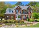 Charming brick home with manicured landscaping and a welcoming entrance with an American flag displayed at 8059 Hogan Dr, Wake Forest, NC 27587