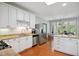 Open kitchen showcases stainless appliances, white cabinetry, granite countertops, and wood floors at 8059 Hogan Dr, Wake Forest, NC 27587