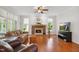 Inviting living room with hardwood floors, a brick fireplace, and abundant natural light from the windows at 8059 Hogan Dr, Wake Forest, NC 27587