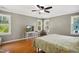 Primary bedroom featuring a ceiling fan, hardwood floors, and three windows at 8059 Hogan Dr, Wake Forest, NC 27587