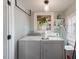Well-lit laundry room with white washer and dryer beneath a hanging pendant light and a window at 812 Northclift Dr, Raleigh, NC 27609