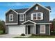 Charming two-story home with a front-facing two-car garage and professionally landscaped yard at 86 Orchard St, Lillington, NC 27546