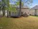 Large backyard featuring a well-maintained lawn, mature shade trees, and a deck with seating at 8921 Walking Stick Trl, Raleigh, NC 27615