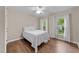 Bright bedroom with hardwood floors and two windows, offering a peaceful retreat at 8921 Walking Stick Trl, Raleigh, NC 27615