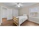 Bright bedroom featuring wood-look floors, a ceiling fan, and a single window with natural light at 8921 Walking Stick Trl, Raleigh, NC 27615
