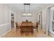 Bright dining room with hardwood floors, stylish lighting, and convenient access to nearby butler's pantry at 8921 Walking Stick Trl, Raleigh, NC 27615