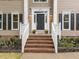 Inviting front entrance featuring brick steps, flower beds, and sidelights on front door at 8921 Walking Stick Trl, Raleigh, NC 27615