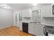 Kitchen featuring white cabinets, black appliances, and hardwood flooring at 903 Norwood Lane Ln, Apex, NC 27502