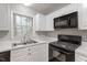 Close up on the kitchen featuring black appliances, a stainless sink and ample cabinets at 903 Norwood Lane Ln, Apex, NC 27502