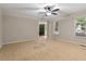 Cozy living room featuring carpet, ceiling fan, and windows offering natural light at 903 Norwood Lane Ln, Apex, NC 27502