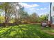 Spacious backyard featuring a fence, mature trees, and a deck with a grill at 9204 Cub Trl, Raleigh, NC 27615
