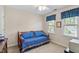 Cozy bedroom featuring a blue daybed, neutral walls, and natural light from two windows at 9204 Cub Trl, Raleigh, NC 27615
