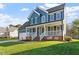 A charming two-story home with blue siding, a welcoming front porch, and a lush green lawn at 9204 Cub Trl, Raleigh, NC 27615