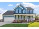 Charming two-story home with a welcoming front porch and blue siding, plus a well-manicured lawn at 9204 Cub Trl, Raleigh, NC 27615