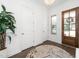 A bright and modern entryway with a dark wood door and floor plus white walls and a decorative carpet at 936 Regency Cottage Pl, Cary, NC 27518