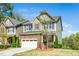 Inviting home featuring a stone and siding facade, a two-car garage, and professionally landscaped front yard at 936 Regency Cottage Pl, Cary, NC 27518