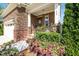 Inviting front porch with brick steps, stone accents, and lush landscaping with elegant column architecture at 936 Regency Cottage Pl, Cary, NC 27518