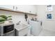 Laundry room with white cabinets, a utility sink, and a modern washer and dryer at 936 Regency Cottage Pl, Cary, NC 27518