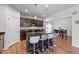 A kitchen boasts a central island with barstool seating and sleek, modern appliances on wood-look floors at 95 Shady Creek Trl, Garner, NC 27529