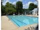 Large community pool with lane markers and lounge chairs with umbrellas, surrounded by trees at 104 Buckeye Ln, Chapel Hill, NC 27516