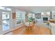 Open dining area with hardwood floors flows into living area with large windows and fireplace at 104 Buckeye Ln, Chapel Hill, NC 27516