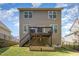 Tan two-story home featuring a wooden deck with stairs, a lawn, and tidy landscaping at 104 Lowe Wood Ct, Durham, NC 27703