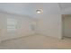 Bright, empty bedroom with neutral walls, two windows, and light carpet at 104 Lowe Wood Ct, Durham, NC 27703