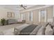 Staged primary bedroom with neutral color palette, bench, and three sunny windows at 104 Lowe Wood Ct, Durham, NC 27703