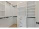 Organized walk-in closet with white shelves, drawers, and hanging rods for efficient storage at 104 Lowe Wood Ct, Durham, NC 27703