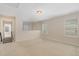 Spacious loft with windows, neutral carpet, and staircase to additional rooms at 104 Lowe Wood Ct, Durham, NC 27703